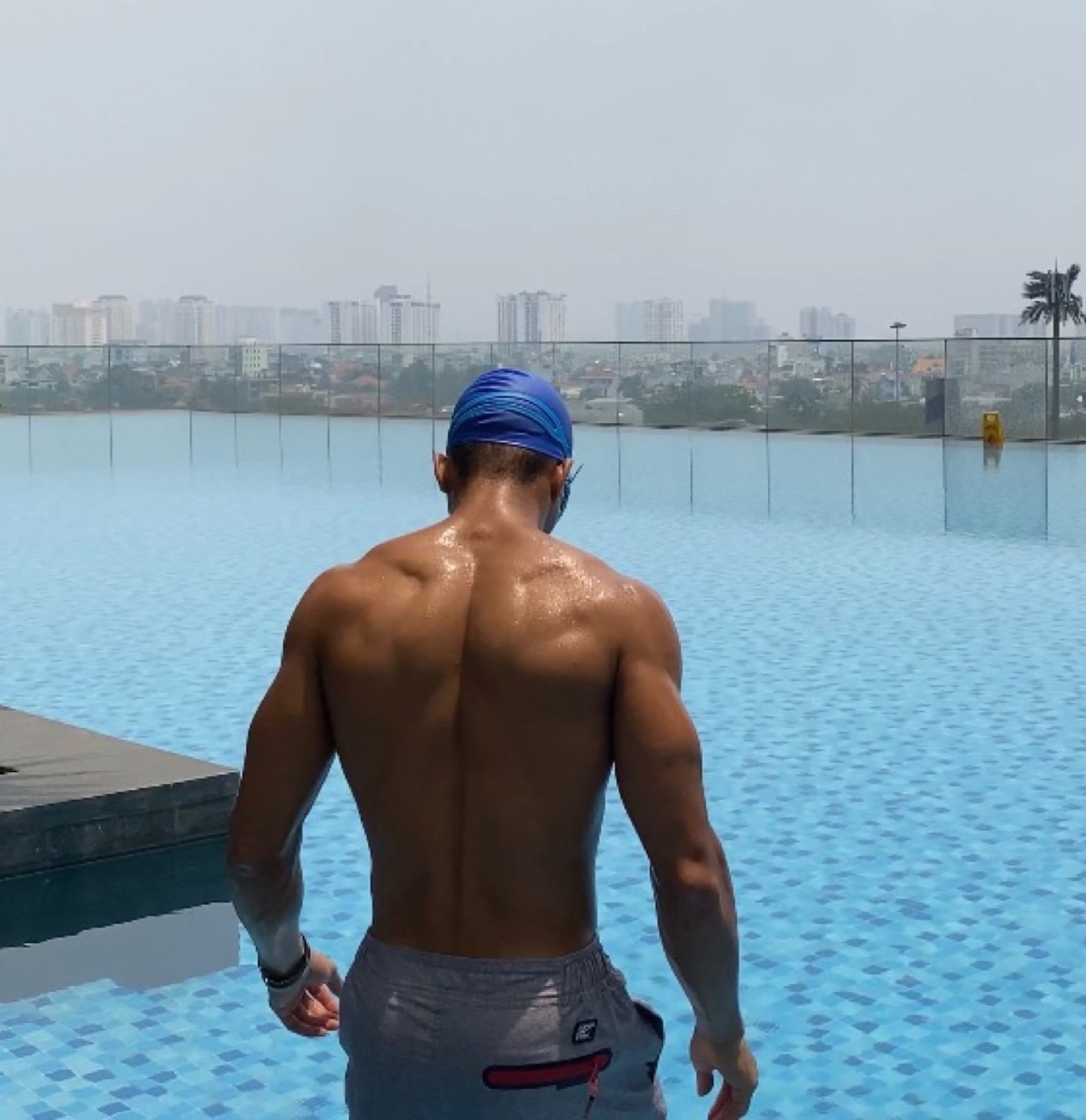 OYOTTA at a rooftop pool with a city skyline